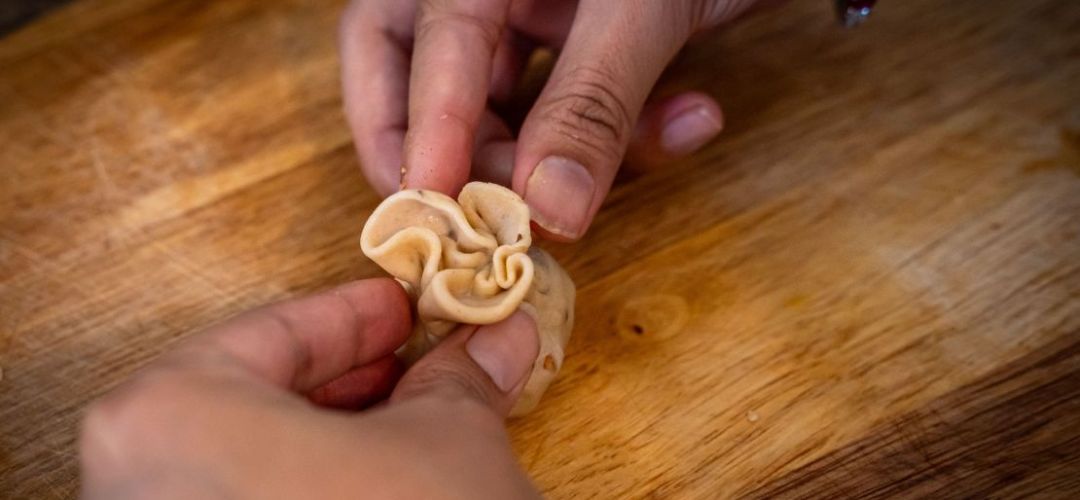 Ein Cashew Samosa Snack wird per Hand geformt