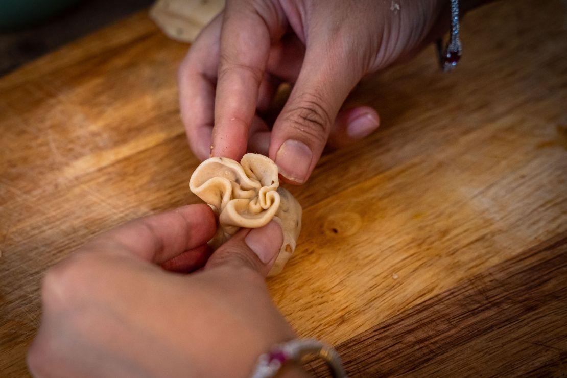 Ein Cashew Samosa Snack wird per Hand geformt