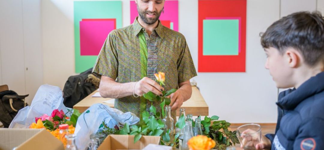 Eine Person bereitet die Blumendeko für die Tische im zuka vor.