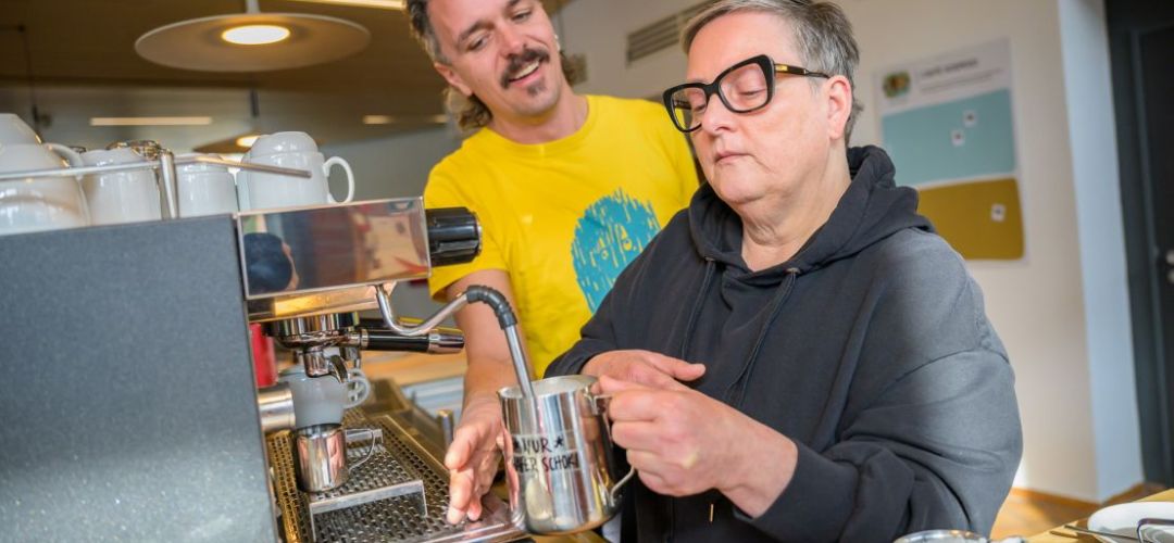 Eine Person lernt wie man Milch aufschäumt.