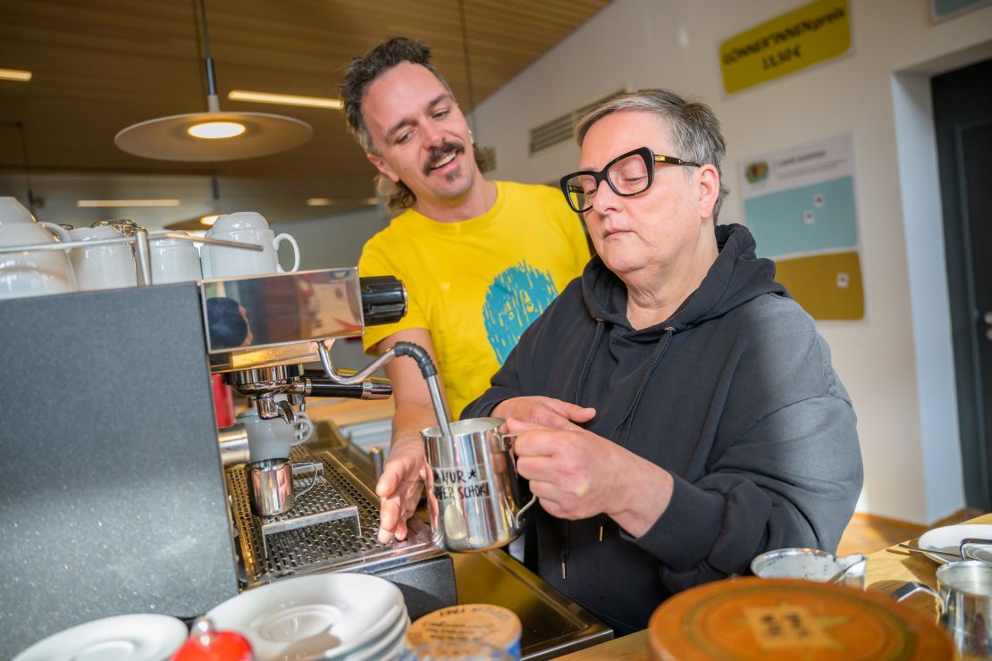 Eine Person lernt wie man Milch aufschäumt.