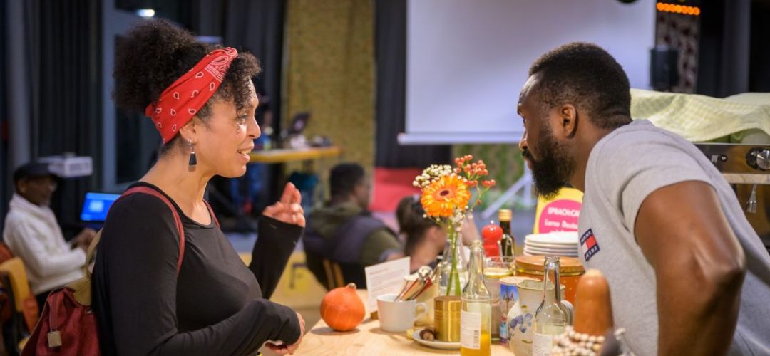 zwei Personen unterhalten sich bei dem Event Afrocafe.