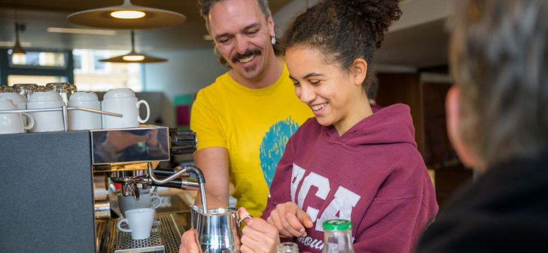Zwei Personen schäumen Milch an der Kaffeemaschine im zuka Solicafe