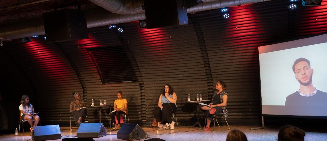 Panel bei der dritten Ausgabe des "Dear White People" Festivals: Militarisierung der EU-Außengrenzen und rassistische, koloniale Asylpolitik. Podiumsdiskussion mit Doris Dede, Dimitra Dermitzaki, Grace Ngángá, Charaf Zerzar. Moderiert von Rebecca Renz und Rufine Songué.