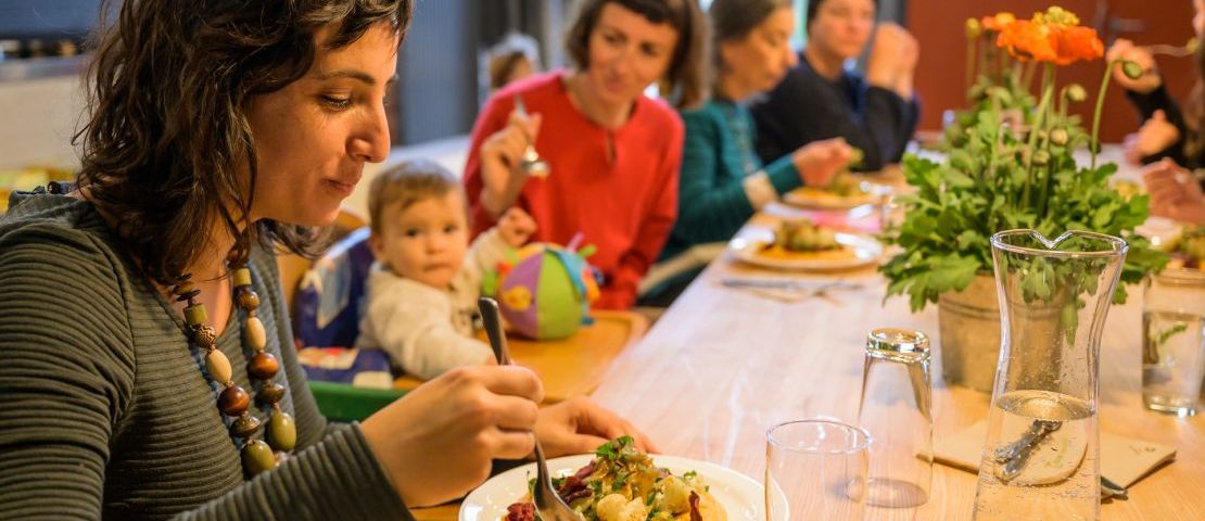 Nahaufnahme von mehreren Personen, die am großen Tisch im zuka solicafe Mittagessen.