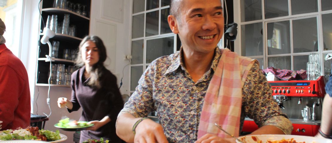 Der Koch Tai bereitet das Mittagessen hinter der Theke persönlich zur Ausgabe vor.