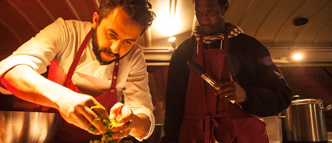 Der Koch Jose Lavor bereitet mit einem Teilnehmenden der Qualifizierung "zusammen in die Zukunft" beim Eventdinner im Layback  die Teller zur Ausgabe vor.