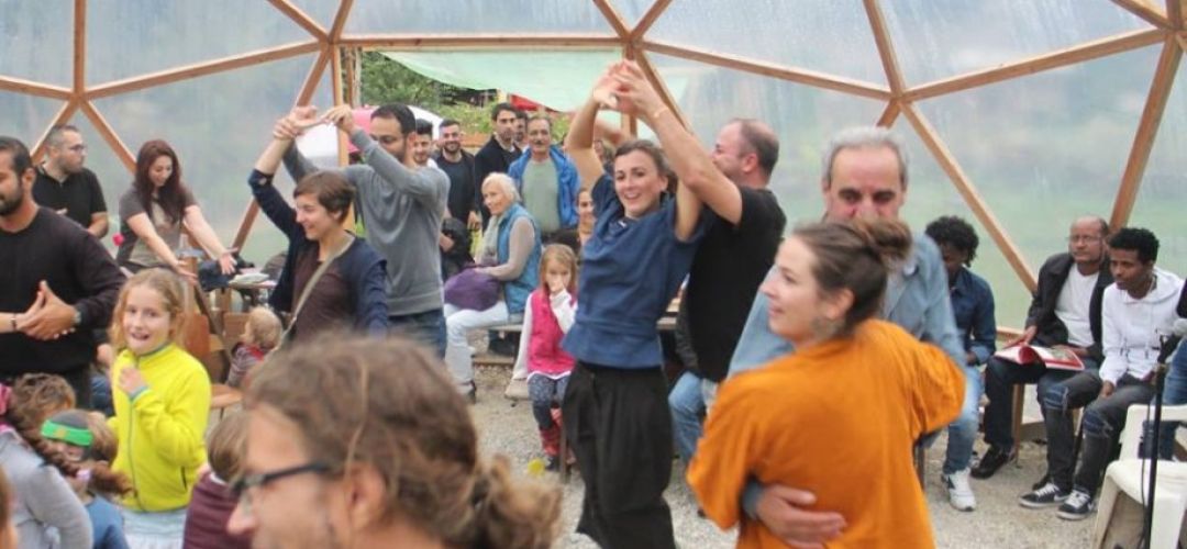 viele Menschen tanzen unter der Kuppel im Gemeinschaftsgarten.